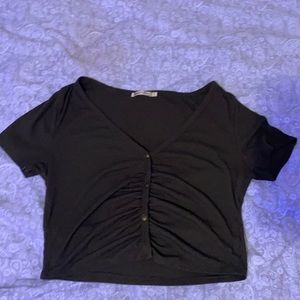 A green cropped buttoned short sleeve shirt.